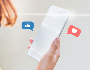 A hand holding a smartphone depicting white-label social media management with a facebook thumbs up sign and an instagram heart sign for likes.