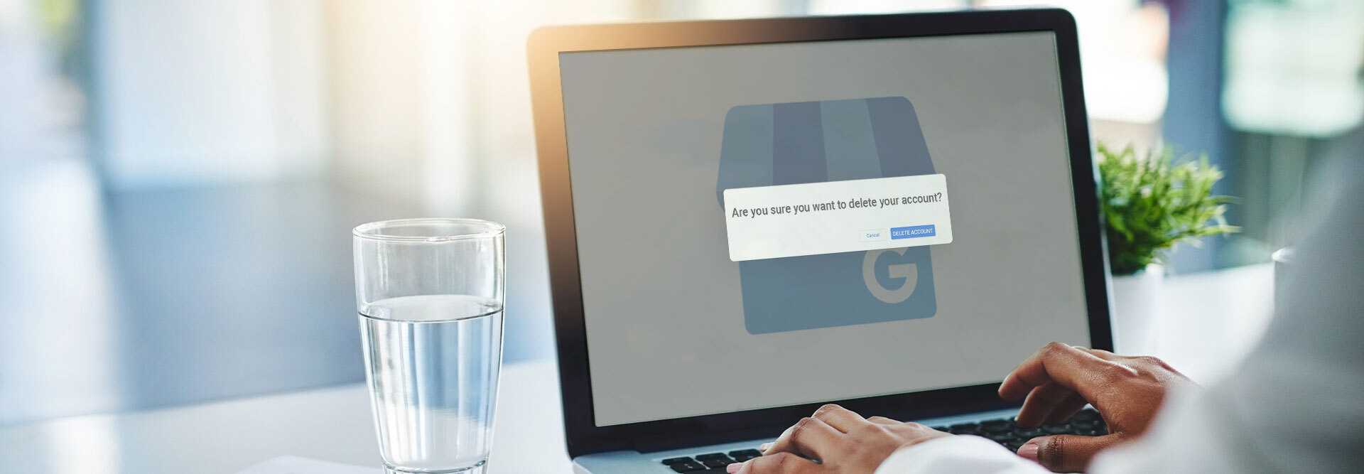 A laptop on a desk displaying the pop-up text “Are you sure you want to delete your Google Business Profile account?”