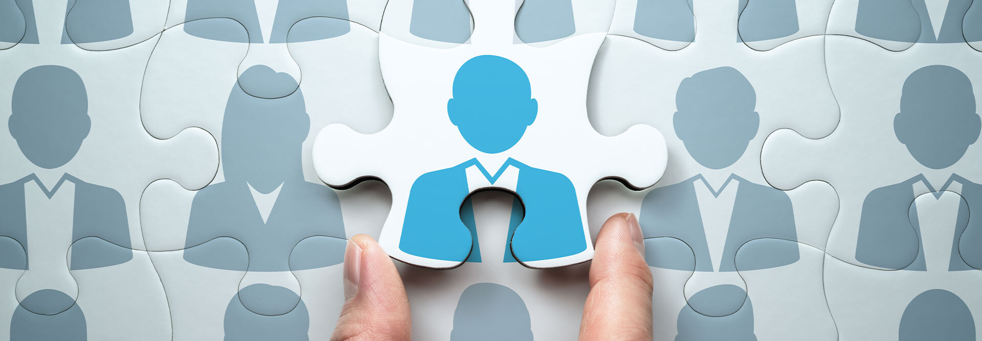 Agency owners hold a puzzle piece featuring a new client ready for marketing agency client onboarding to be added into the framework of the agency’s existing book of business