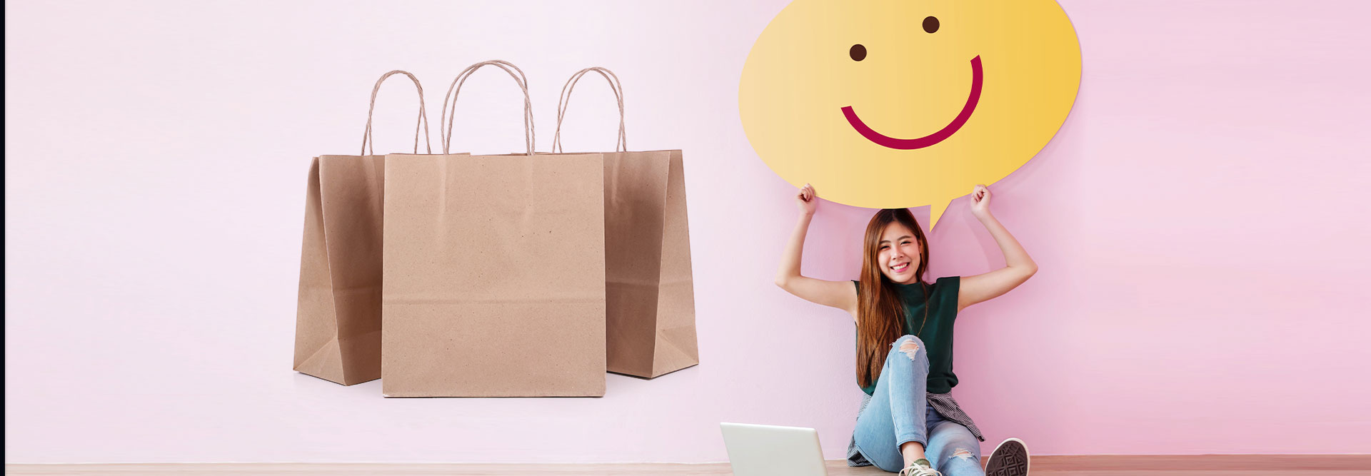 A customer holding a giant yellow happy face, with shopping bags off to the side.